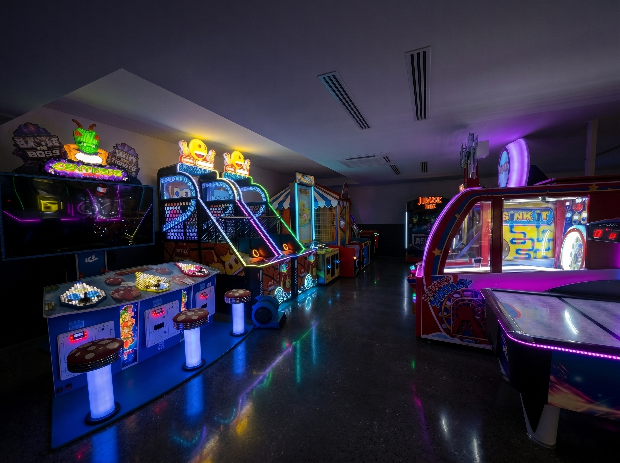 Neon-lit arcade with classic games, skee-ball, and air hockey