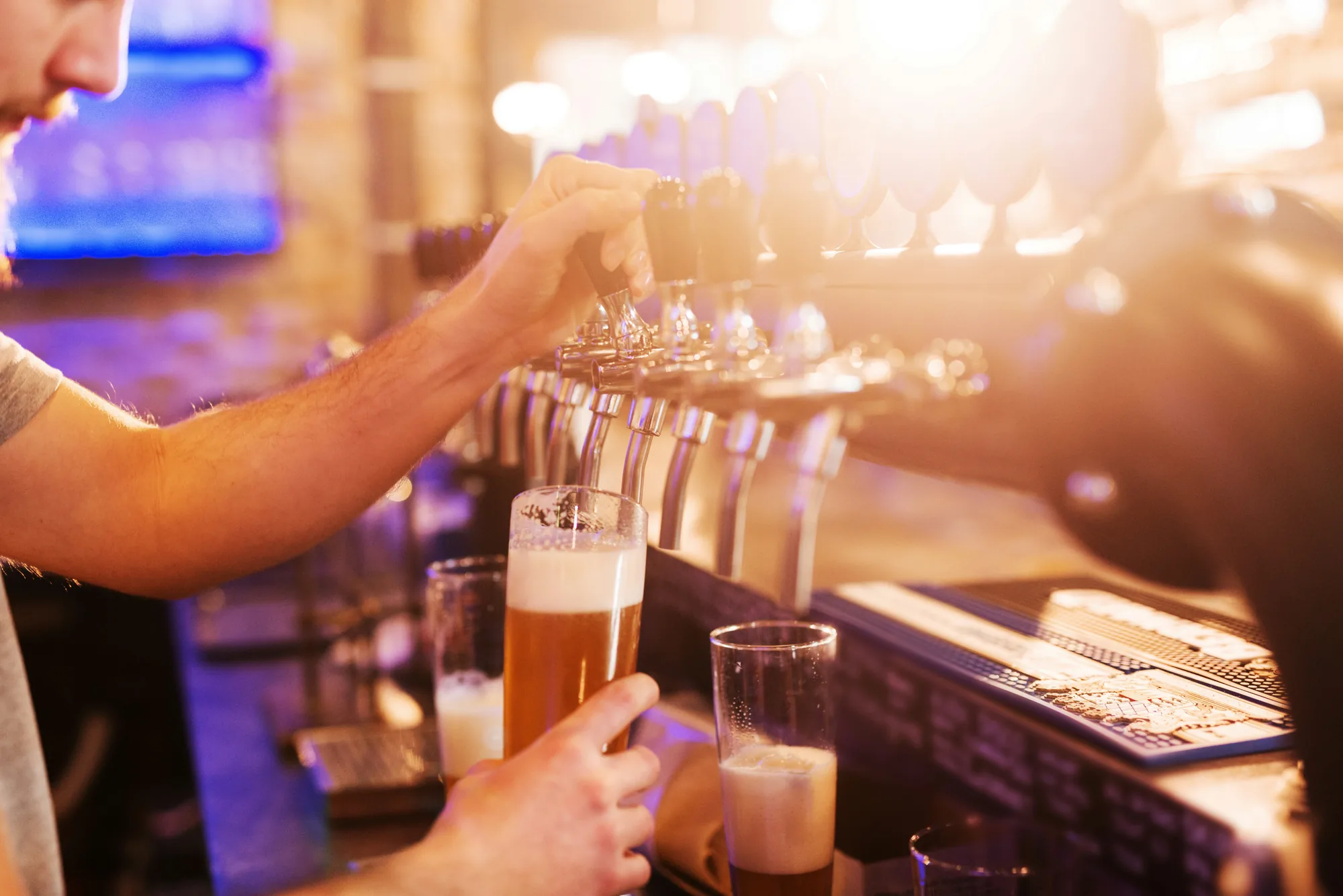 A cold draft beer being poured from the taps at the Red Apple bar